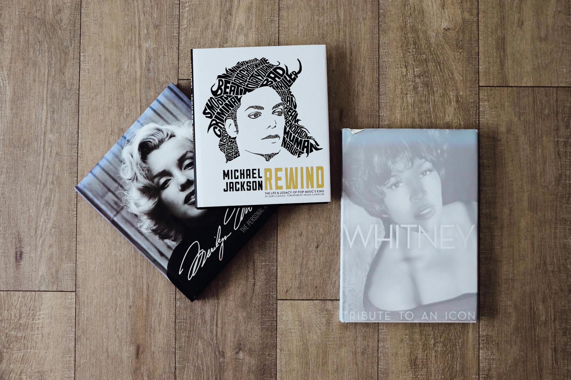 Chocolate in Pop Culture: The Best Tasty Flicks & Reads Books featuring Marilyn Monroe, Michael Jackson, and Whitney Houston on a wooden floor.