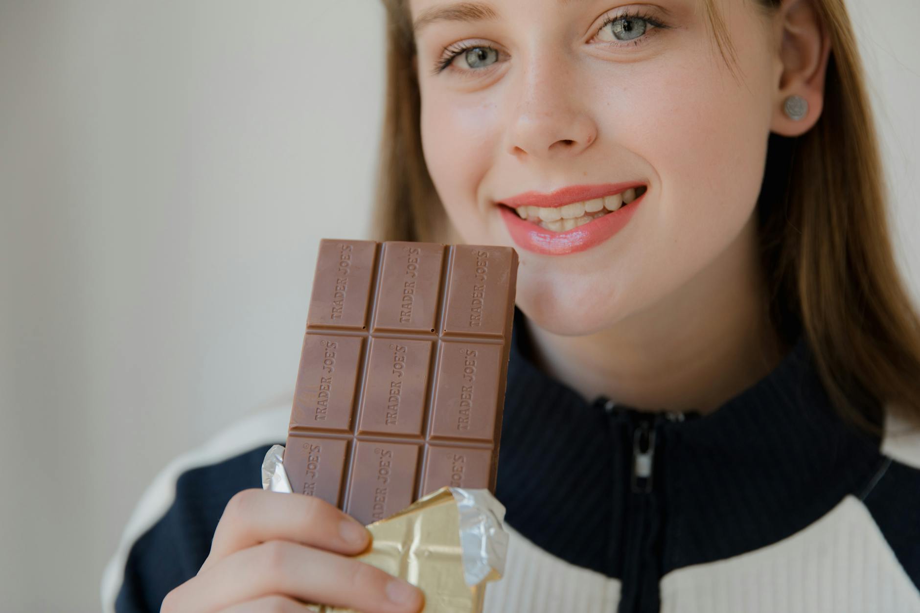 Chocolate Bar Buying Guide: Best Tips for Your Taste Smiling woman holding a chocolate bar, enjoying the sweet treat.