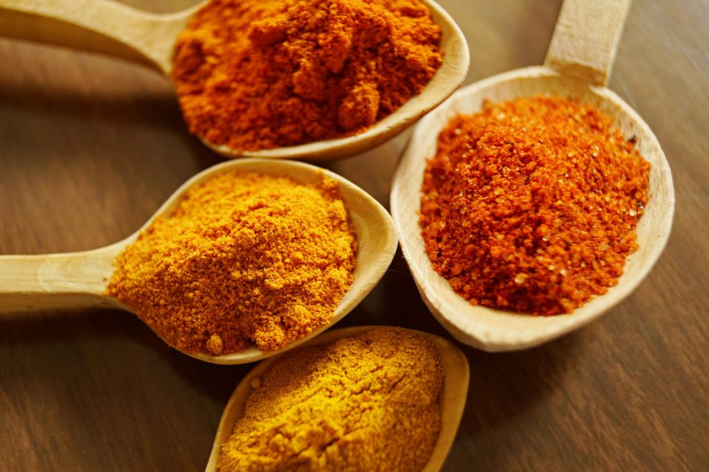 Pair Chocolate with Spices for Bold Flavors - Discover the Best Combos Close-up of vibrant spices like turmeric and chili powder in wooden spoons.