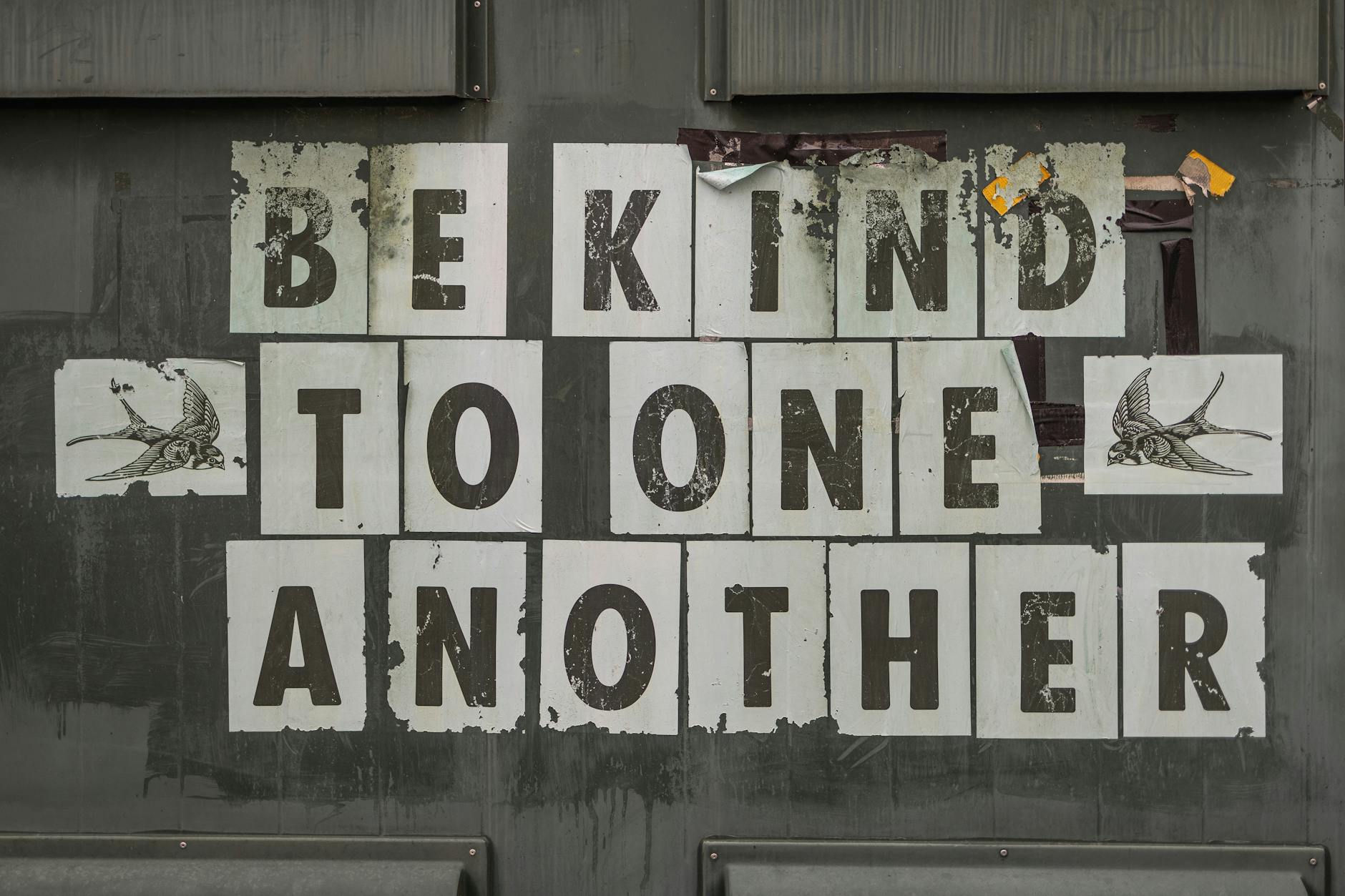 Ethical Chocolate Production: Ultimate Guide for Sustainable Indulgence Close-up of 'Be Kind to One Another' message on a weathered background.