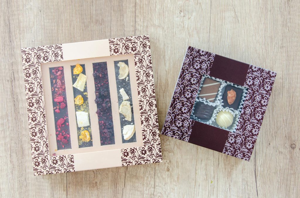 Chocolate Cookbooks: Must-Have Bestsellers Top view of assorted chocolate gift boxes with elegant designs on a wooden table, perfect for gifting or special occasions.