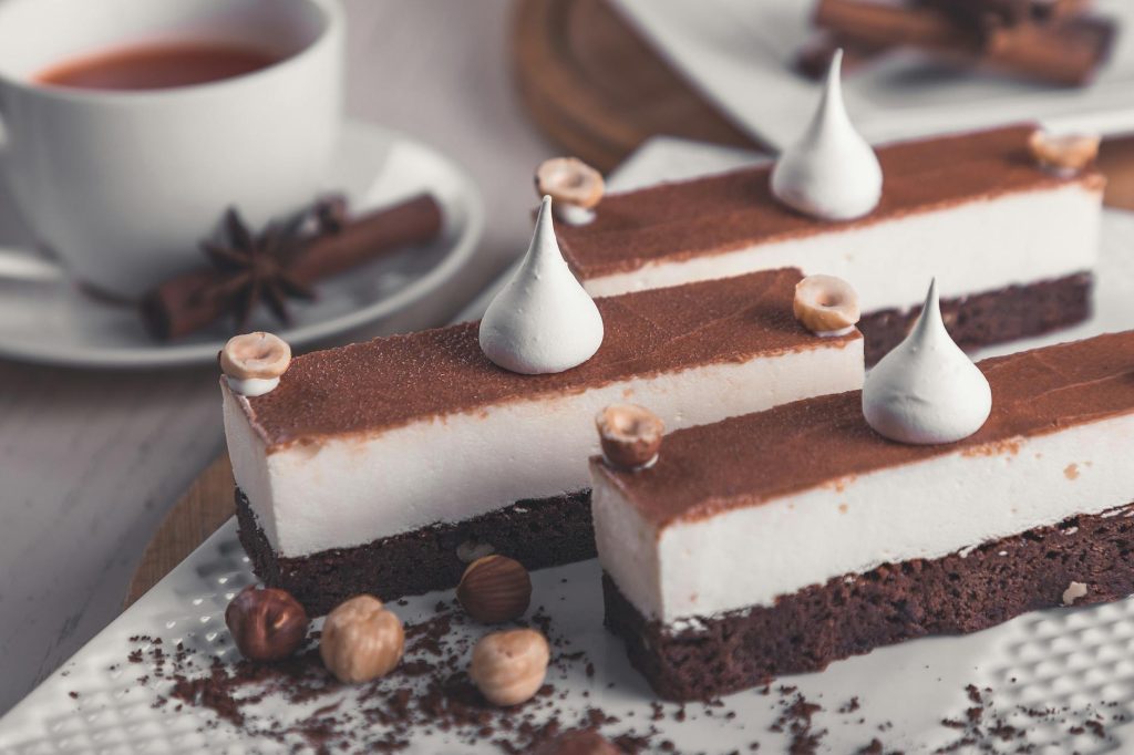 Chocolate Pairing Guide: Best Wine, Coffee, and More Rich chocolate mousse bars topped with meringue and hazelnuts, perfect for dessert lovers.