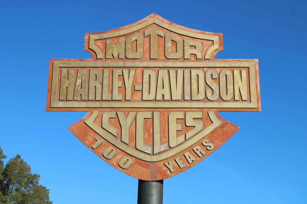 Chocolate Advertising: Uncovering the Sweet Evolution A striking Harley-Davidson 100 years sign set against a vibrant blue sky.