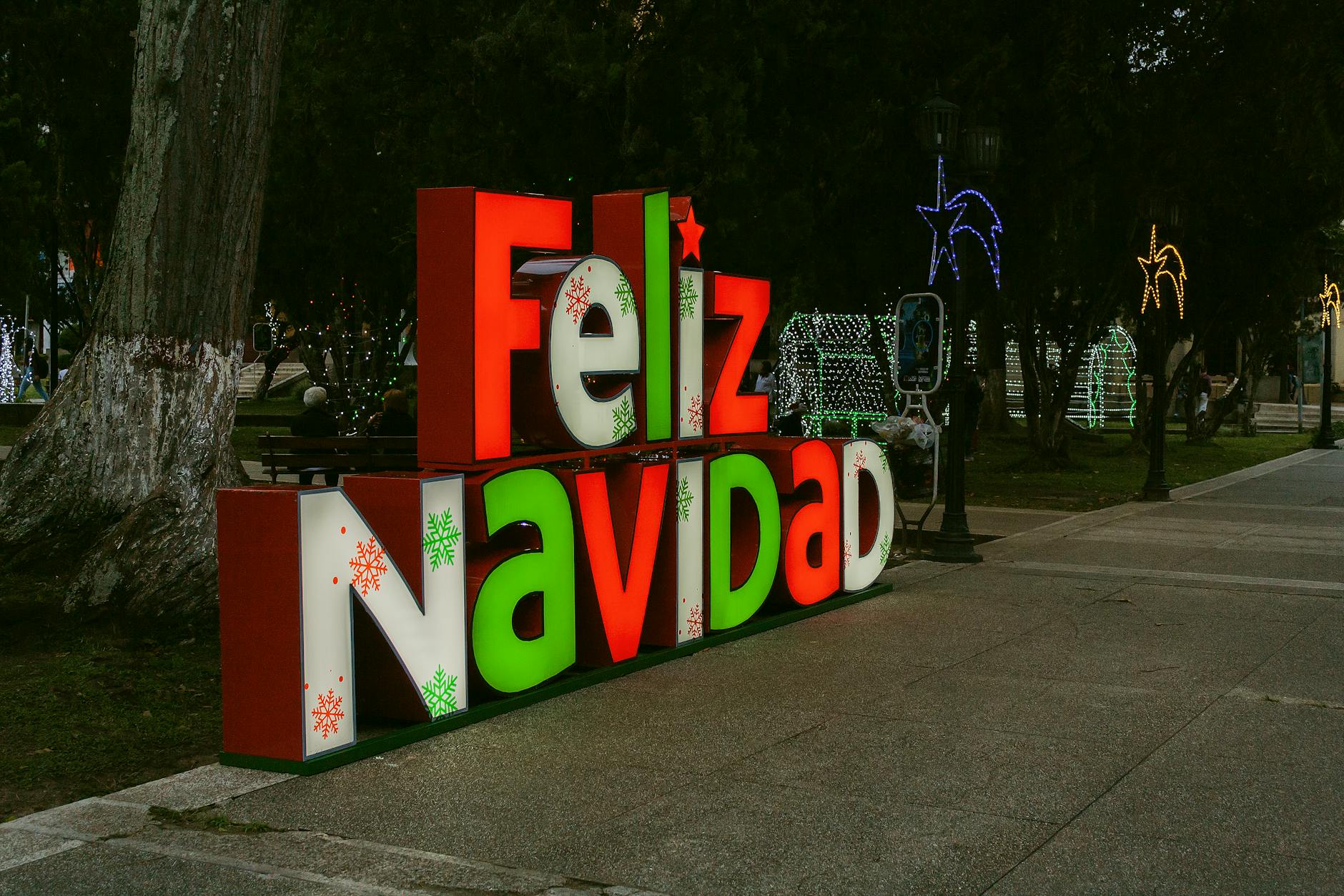 Colorful Feliz Navidad sign with festive lights in Mérida, Venezuela park setting.
